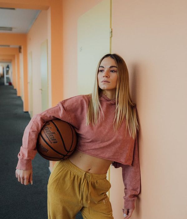 Woman in a light active pose in a minimalist room.